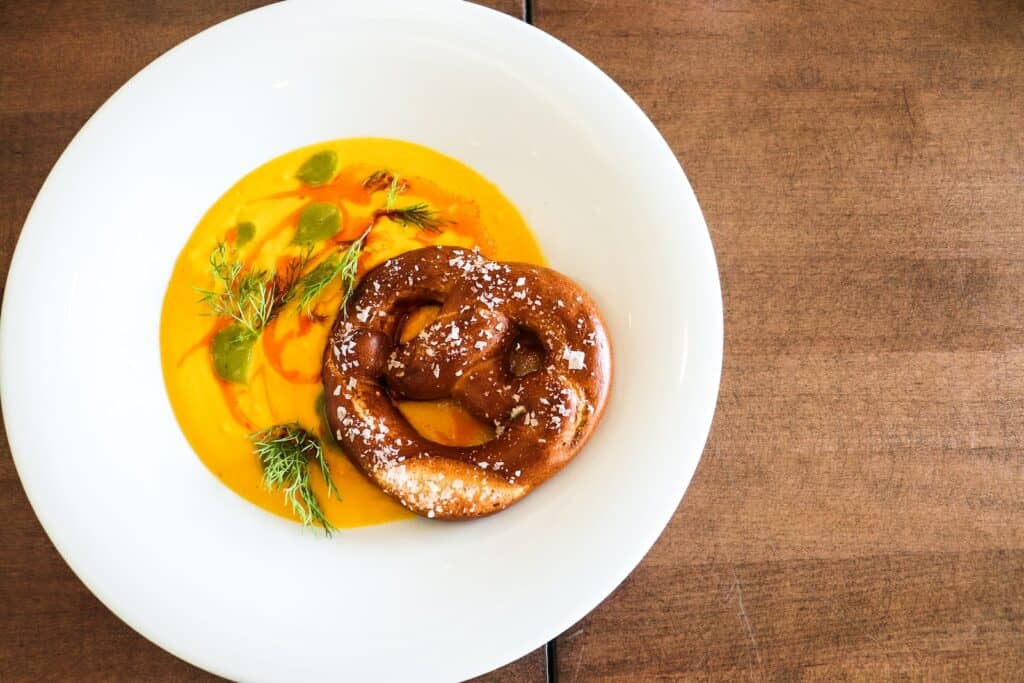 soups with butternut squash, brown doughnut on white ceramic plate