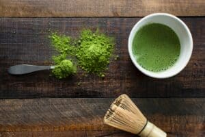 green plant in white ceramic mug beside brown wooden brush